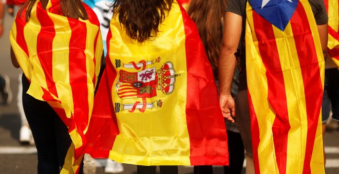 Jóvenes cubiertos con la bandera esañola, la senyera, y la estelada, en la manifestación en Barcelona durante la jornada de paro en protesta por las cargas policiales durante el referéndum del 1-O. REUTERS/Jon Nazca