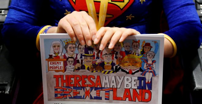 Una mujer sostiene un dibujo sobre el Brexit durante la rueda de prensa de los negociadores de la UE y del Reino Unido, en Bruselas. REUTERS/Francois Lenoir