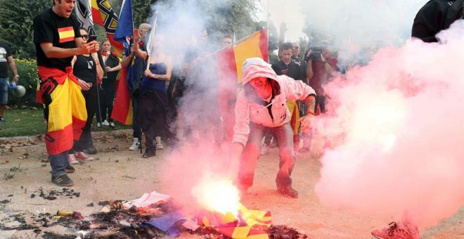 Jóvenes de ultraderecha queman estelades durante la manifestación en defensa de la unidad nacional en la plaza de Sant Jordi, en Barcelona./EFE