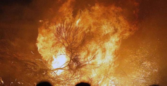 Varias personas observan un incendio en Chandebrito. | LAVANDEIRA JR. (EFE)