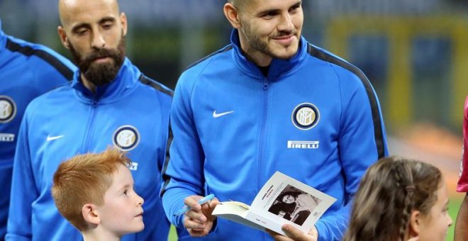 El capitán del Inter de Milán, Mauro Icardi, firma una copia de "El diario de Ana Frank" para un niño antes de un partido de la Serie A italiana entre el Inter de Milán y el UC Sampdoria. /EFE
