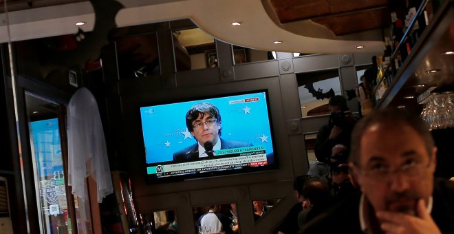 La comparecencia del expresident catalán Carles Puigdemont en Bruselas, en un televisor en un bar cerca de la Plaza de Sant Jaume de Barcelona, el pasado 31 de octubre. REUTERS/Jon Nazca