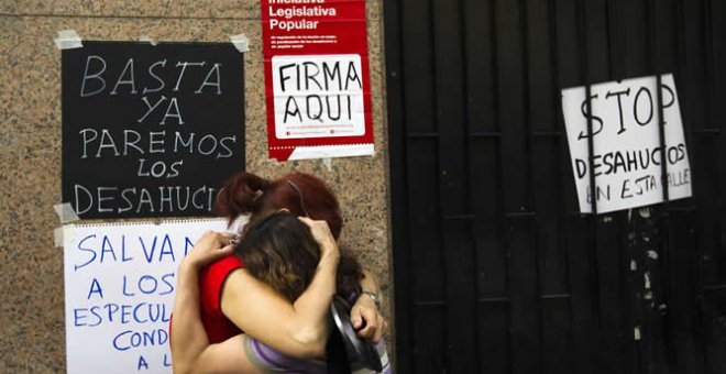 Dos mujeres se abrazan en la puerta de la casa de la que acaban de ser desahuciadas en Madrid, en 2012.- REUTERS/SUSANA VERA (ARCHIVO)