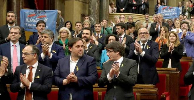 Carles Puigdemont y Oriol Junqueras, aplauden junto a los diputados de JxSí y la CUP. EFE