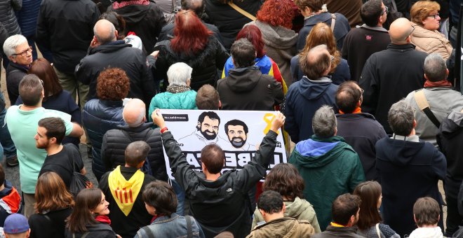 Un manifestante con una pancarta reclamando la puesta en libertad de los presidentes de ANC y Omnium Cutural, Jordi Sanchez y Jordi Cuixart, respectivamente, en la concentración en la Plaza de Sant Jaume durante la jornada de huelga general en Catalunya.