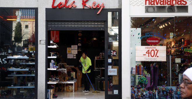 Un empleado de una tienda en el centro de Madrid limpia la entrada del establecimiento. REUTERS
