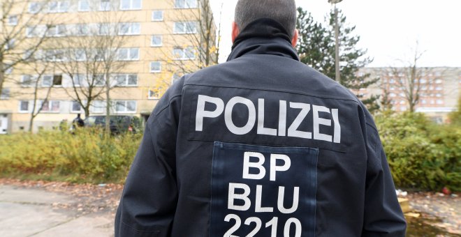 Un agente de la policía alemana frente a un edificio residencial en Schwerin. / Reuters