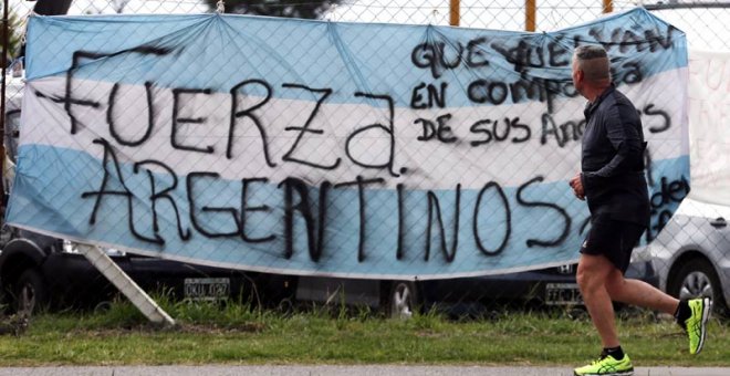 Un hombre pasa ante una bandera argentina colocada en la base naval de Mar del Plata. | REUTERS
