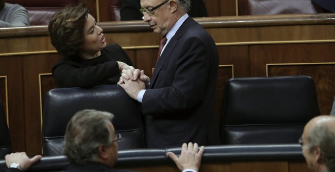 El ministro de Hacienda, Cristóbal Montoro, conversa con la vicepresidenta del Gobierno, Soraya Sáenz de Santamaría, al terminar el pleno del Congreso que ha aprobado la reforma del Concierto Económico con el País Vasco y el nuevo cupo.EFE/Zipi