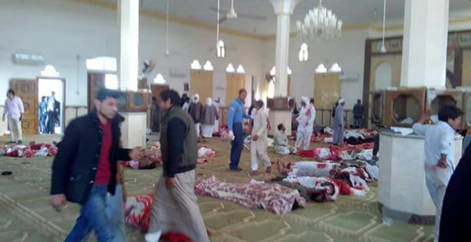 Varias personas permanecen junto a cuerpos sin vida en el interior una mezquita contra la que se ha perpetrado un ataque, en la ciudad de Al Arish, en el norte de la península del Sinaí (Egipto), hoy 24 de noviembre de 2017. Al menos 54 personas murieron