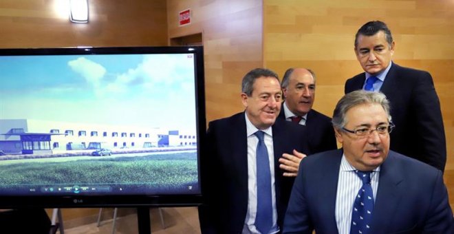 El ministro del Interior, Juan Ignacio Zoido (d), acompañado del delegado del Gobierno en Andalucía, Antonio Sanz (2d), junto a un monitor donde se encuentra una recreación de los nuevos (CIE), hoy durante la presentación en Algeciras (Cádiz).- EFE/A.Carr