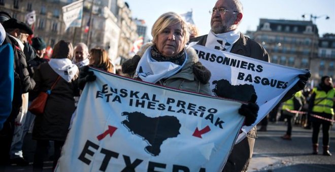 Una mujer sujeta una pancarta en París que pide la reagrupación de los presos de ETA.EFE/Julien de Rosa