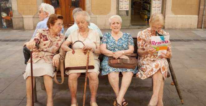 Cuatro mujeres mayores sentadas en un banco una plaza de Barcelona. AFP