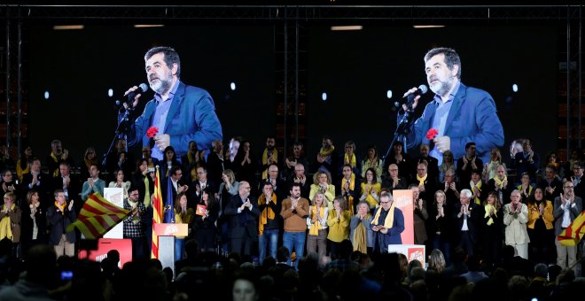 La imagen del presidente de ANC y número dos de la lista de Junts per Catalunya aparece en sendas pantallas mientras por megafonía suena una grabación de su voz, en un mitin de la candidatura soberanista en Barcelona. REUTERS/Albert Gea