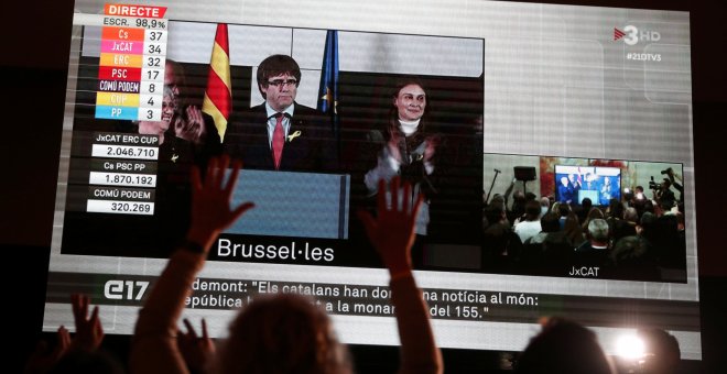 Los seguidores de JxCat observan en una pantalla en Barclona la intervención del president cesado Carles Puigdemont, valorando desde Bruselas los resultados de las elecciones del 21-D.. REUTERS/Albert Gea