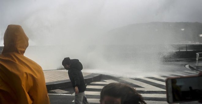 Varias personas son sorprendidas por una ola en el Paseo Nuevo de San Sebastián, durante el paso del temporal de invierno Bruno, que ha dejado rachas muy fuertes de viento y ha provocado olas de hasta siete metros. EFE/Javier Etxezarreta.