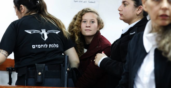 La adolescente palestina  Ahed Tamimi, es escoltada por agentes de la policía israelí hacia un juzgado en la localidad de Betunia (Palestina). EFE/ Abir Sultan