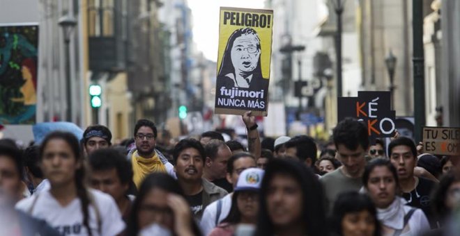 Manifestantes participan con banderas y pancartas durante una marcha contra el indulto otorgado a Alberto Fujimori en Lima. - EFE