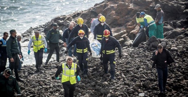 Efectivos de los servicios de Emergencias trasladan el cuerpo de uno de los fallecidos en la playa Bastián de Costa Teguise, donde seis inmigrantes magrebíes han perdido la vida y otros dos se encuentran en estado crítico tras encallar este mediodía una p