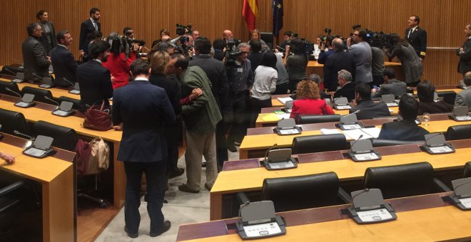 El ministro de Economía, Luis de Guindos, rodeado de fotógrafos antes comenzar su comparecencia en la comisión de investigación de la crisis financiera en el Congreso. /EFE