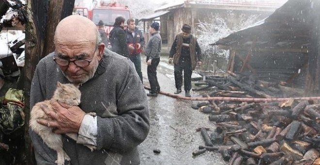 Anciano abrazando al gato superviviente tras el incendio de su casa. Facebook / NTV Radyo