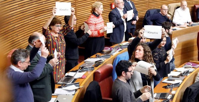 Los diputados de Podemos muestran carteles con el lema "#Campsfora" en el pleno de Les Corts Valencianes tras la votación de la propuesta de Compromís para instar a Camps a renunciar como miembro del Consell Jurídic Consultiu y al resto de prerrogativas q