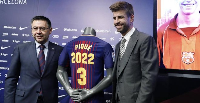 Piqué posa con el presidente del Barcelona, Josep María Bartomeu, tras ampliar su contrato. / ANDREU DALMAU (EFE)
