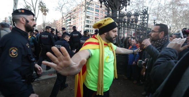Un hombre se interpone entre los Mossos D'esquadra y los manifestantes durante las protestas frente al Parlament. EFE/Toni Albir