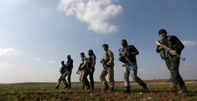 Combatientes kurdos que luchan junto con el Ejército Sirio Libre, caminan juntos en el norte de la campiña de Alepo. REUTERS / Khalil Ashawi