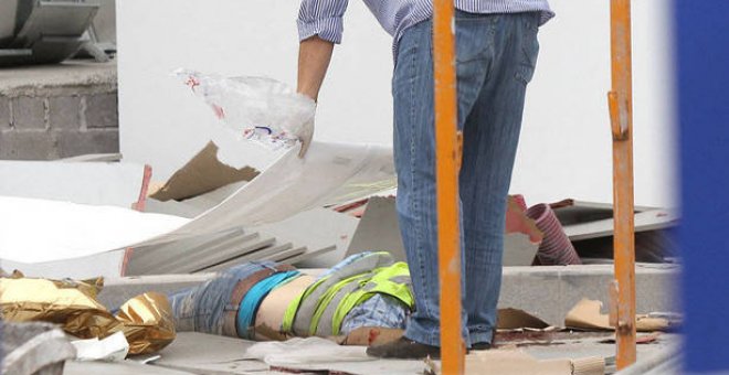 Una persona cubre con un plástico el cadáver de un trabajador fallecido (Imagen de archivo). (EFE)