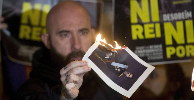 El concejal de la CUP en el Ayuntamiento de Barcelona Josep Garganté quema una foto del Rey./ EFE
