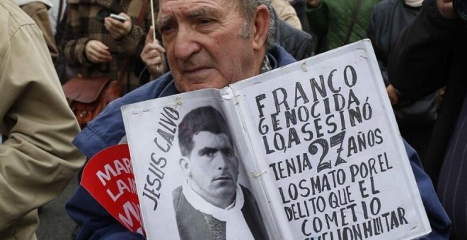 Un hombre muestra una foto de una víctima del franquismo. EFE/Paco Campos