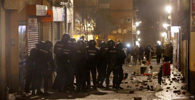 Policías antidisturbios en la calle Mesón de Paredes con la calle del Oso, en el barrio de Lavapiés de Madrid, repelen las protestas tras la muerte de un mantero de un paro cardíaco durante un control policial. | JAVIER LIZÓN (EFE)