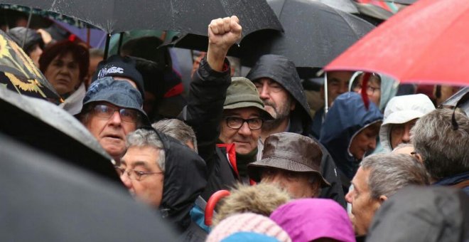 Manifestantes pensionistas se guarecen bajo la lluvia en los alrededores de la Puerta del Sol, el sábado por la mañana.  @MorenoG_Agustin