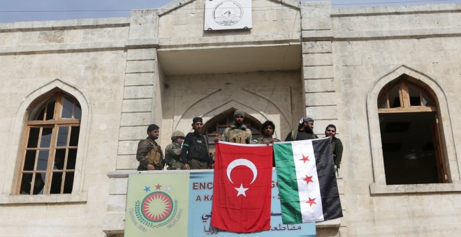Los miembros de las fuerzas turcas y del Ejército Sirio Libre posan con sus banderas mientras se despliegan en Afrin, Siria.REUTERS