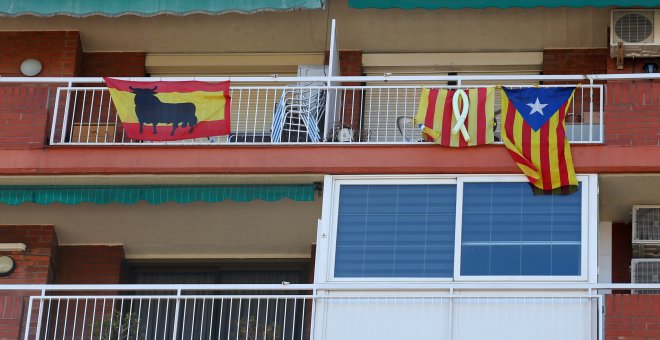 Banderas de España (con el toro de Osborne), la senyera (con el lazo amarillo por los políticos encarcelados), y la estelada, en unos balcones en Barcelona.. REUTERS/Albert Gea