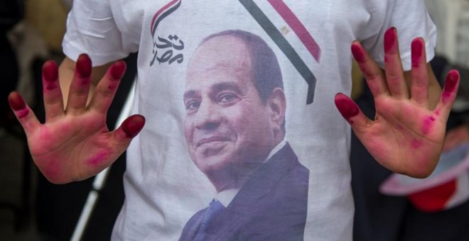 Decenas de personas mostraban banderas nacionales y fotografías del actual presidente egiptcio, Abdelfatah al Sisi, a su salida de un colegio electoral durante la última jornada de votaciones para las elecciones presidenciales. Mohamed Hossam (EFE)