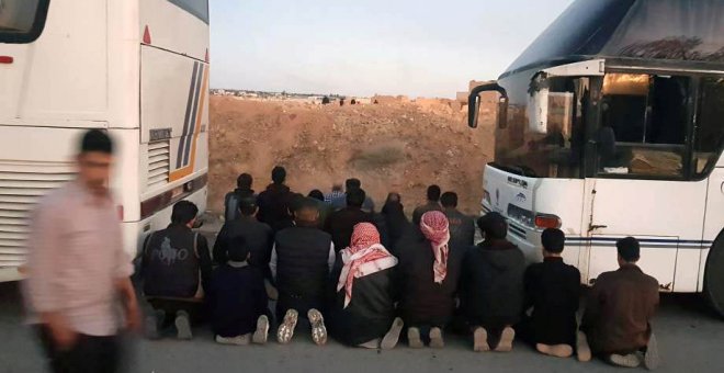 Rebeldes sirios rezan antes de ser evacuados. - REUTERS