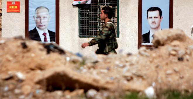 Un soldado sirio pasa junto a dos retratos de Bashar al Assad y Vladimir Putin en la ciudad de Guta. /REUTERS