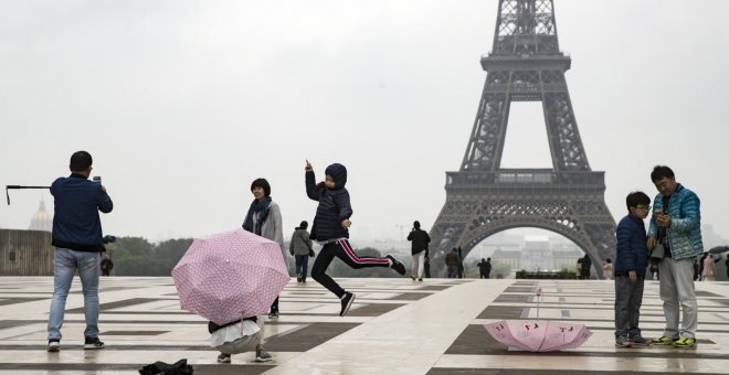 Dos turistas nipones se toman fotos delante de la torre Eiffel en Trocadero, París (Francia). EFE/Archivo