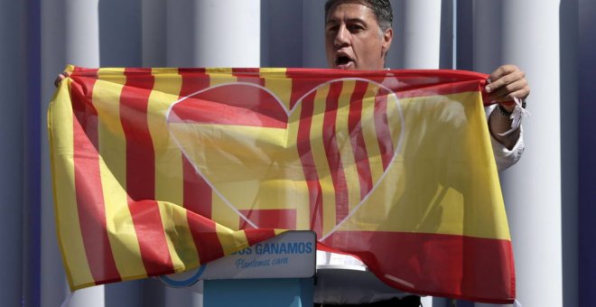 El presidente del PP catalán, Xavier García Albiol, porta en Badalona una bandera con los colores de la senyera y la enseña rojigualda. EFE/Archivo
