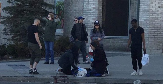 Una víctima del atropello masivo en Toronto es ayudada por otros peatones. (REUTERS)