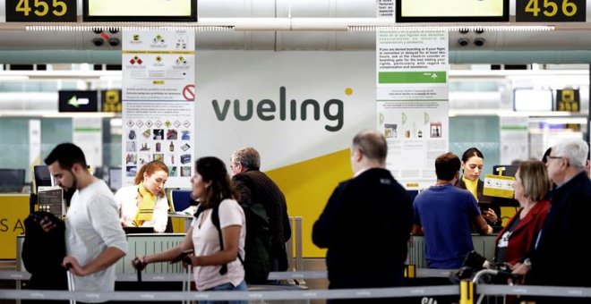 Un grupo de pasajeros ante un mostrador de facturacion de Vueling en el Aeropuerto de Barcelona-El Prat. / EFE