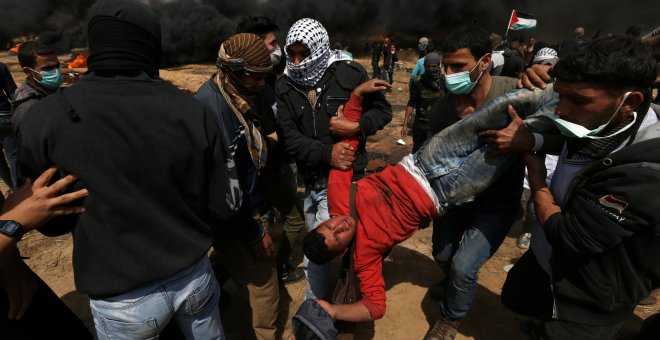 Varios palestinos trasladan a un herido. - REUTERS