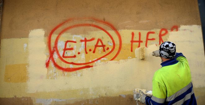 Un empleado municipal tapa una pintada que pone 'ETA, el pueblo está contigo', en Gernica, en octubre de 2011, al día siguiente del anunio de la organización terrorista del cese de su actividad armada. REUTERS/Vincent West