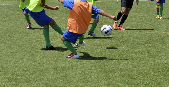 Foto de archivo de unos niños jugando al fútbol. / EFE