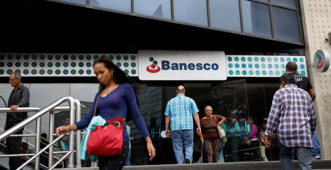 Varias personas llegan a una sucursal del banco Banesco  en Caracas,. REUTERS/Carlos Garcia Rawlins