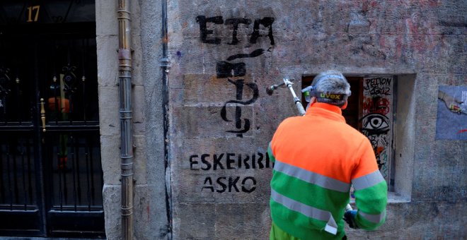 Un emlpeado municipal limpia en Bilbao una pintada que dice, en vasco, 'ETA gracias', dos días después del anuncio de disolución de la organización terrorista. REUTERS/Vincent West