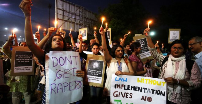 La gente sostiene velas y pancartas durante una protesta contra la violación de una niña de ocho años en Kathua/Reuters
