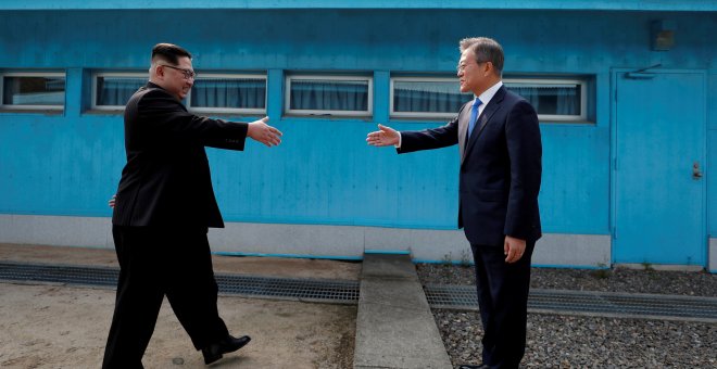 El presidente de Corea del Sur, Moon Jae-in, al estrechar la mano al líder norcoreano, Kim Jong Un, en la frontera entre ambos países el pasado 27 de abril. /REUTERS